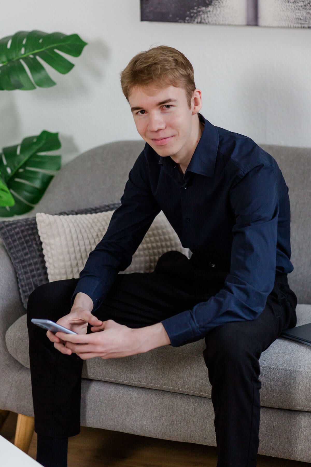 lässiges Businessfoto auf der Couch mit Handy